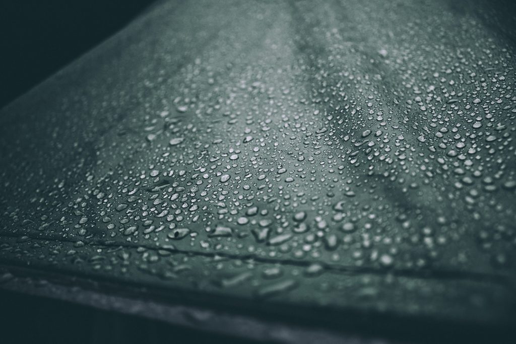 Water drops on surface of black woven fabric