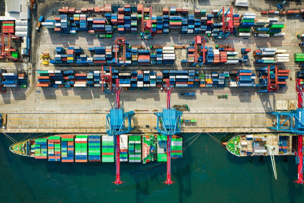 An aerial view of ships and containers at an exporters hub.