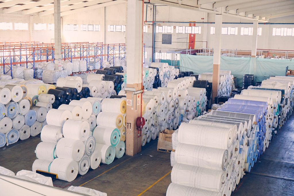 Rolls of PP polymer on the warehouse floor at Custom Bulk Bags in Durban.