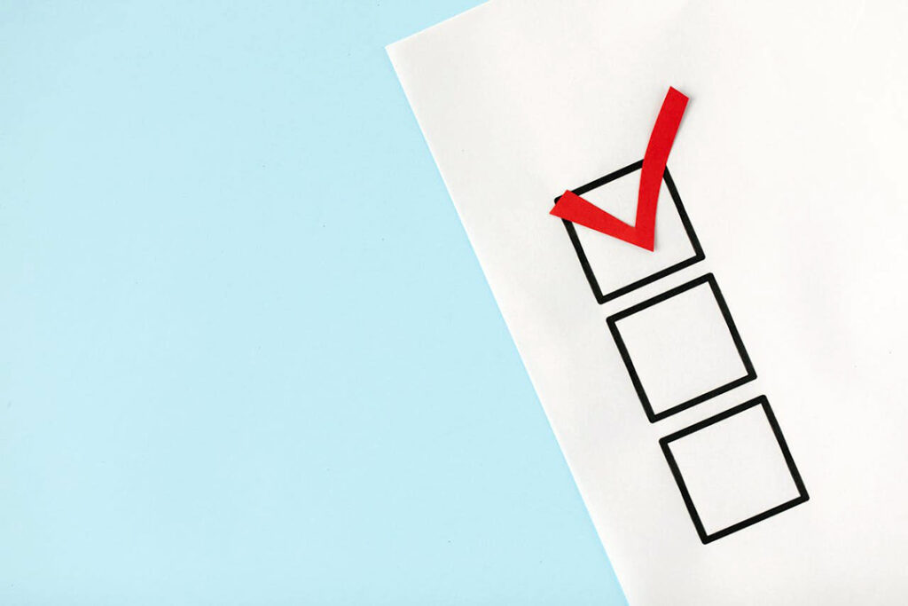 A red paper tick on a paper checklist