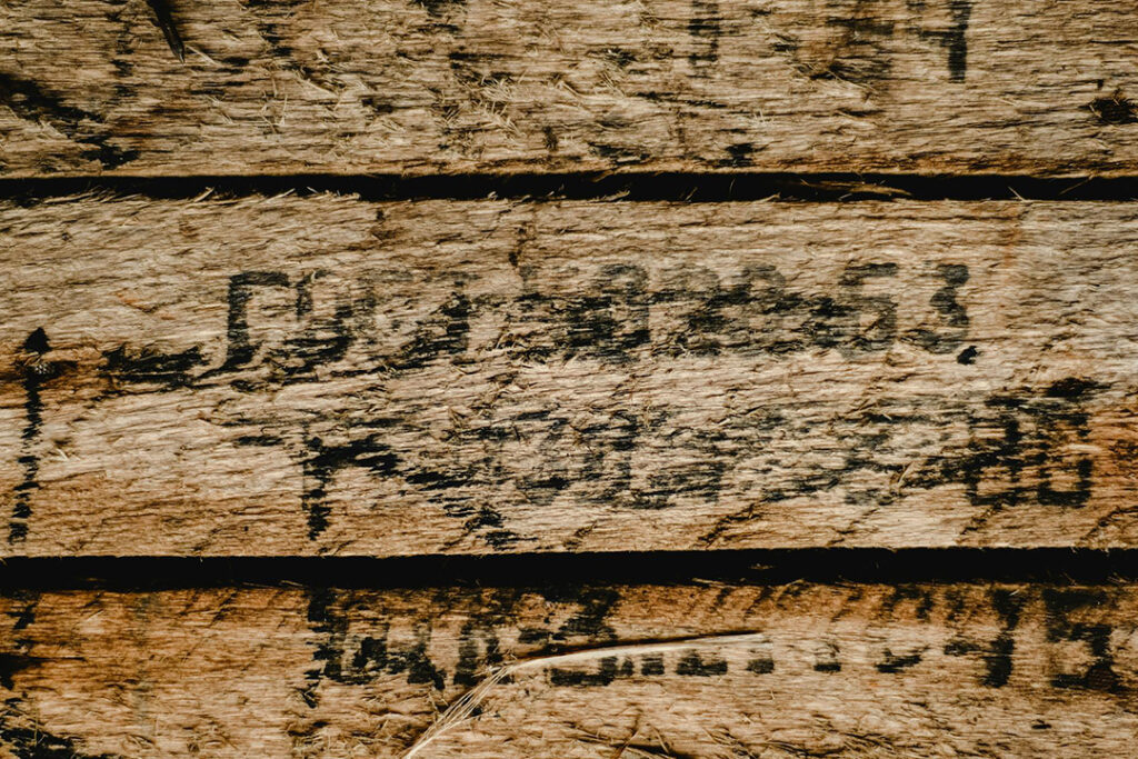 A close-up of an old wooden pallet with a splintered surface.