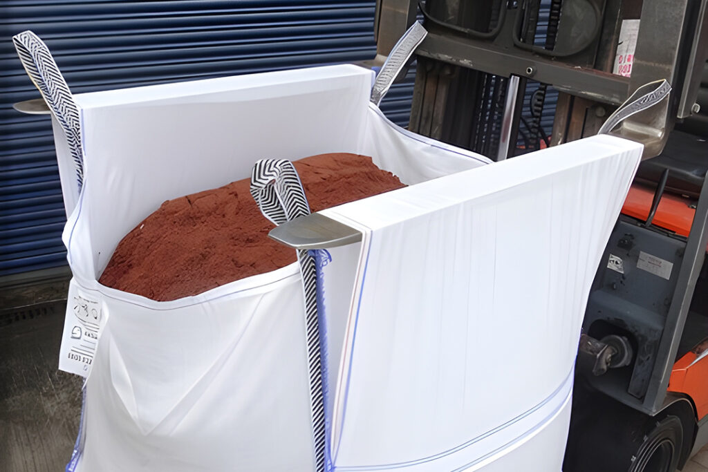 Forklift tines penetrating tunnel sleeves on a white bulk bag