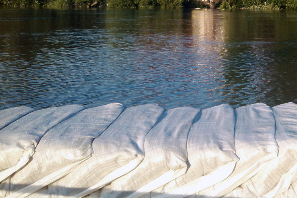Sand bags line a flooded river