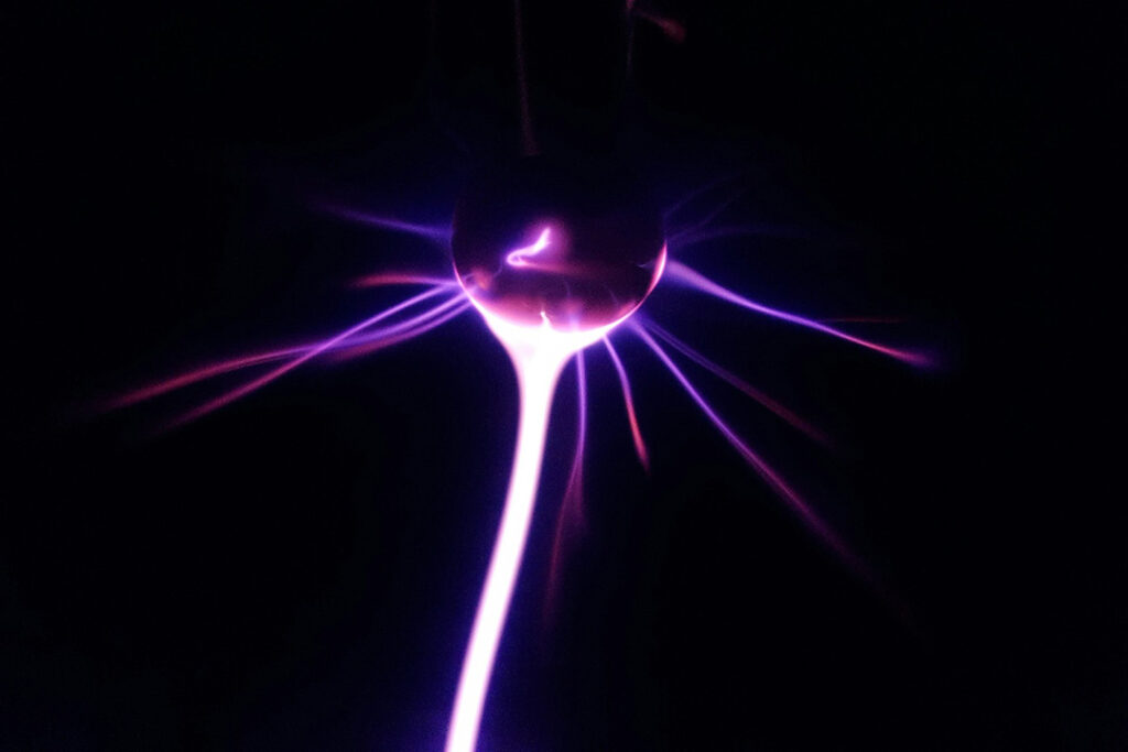 A pink and purple electrostatic discharge from a small Van der Graaf generator.