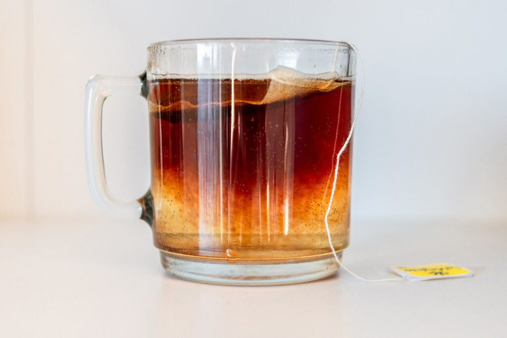 A glass tea cup with a tea bag inside