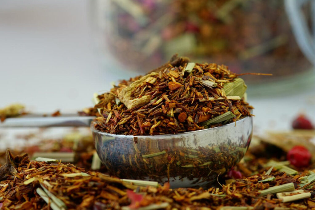 A metal spoon of dried rooibos tea