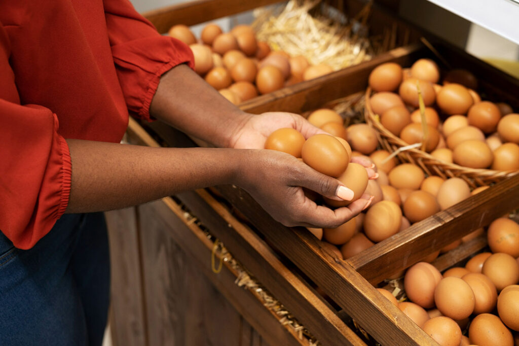 A woman holding a bunch of chicken eggs in her hands.