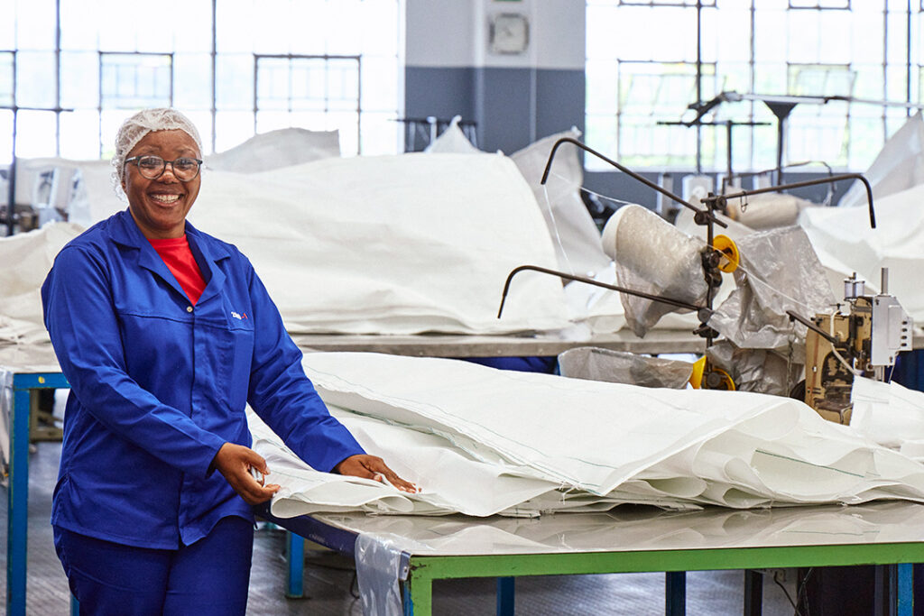 An employee stands next to partly finished FIBCs at CBB's manufacturing facility in Durban.