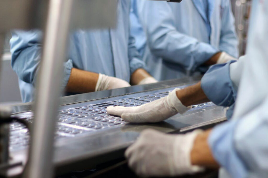 Two workers inside a pharmaceutical manufacturing facility.